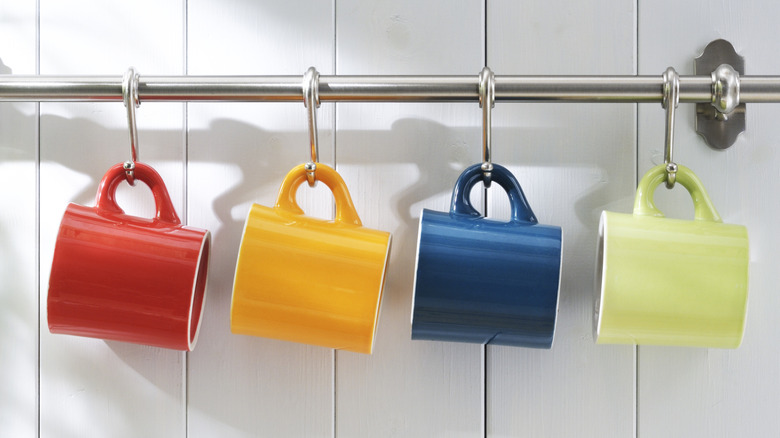 Những chiếc cốc đầy màu sắc treo trên thanh kim loại