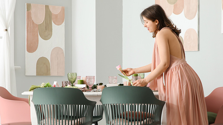 Người phụ nữ mặc váy hồng bày bàn ăn