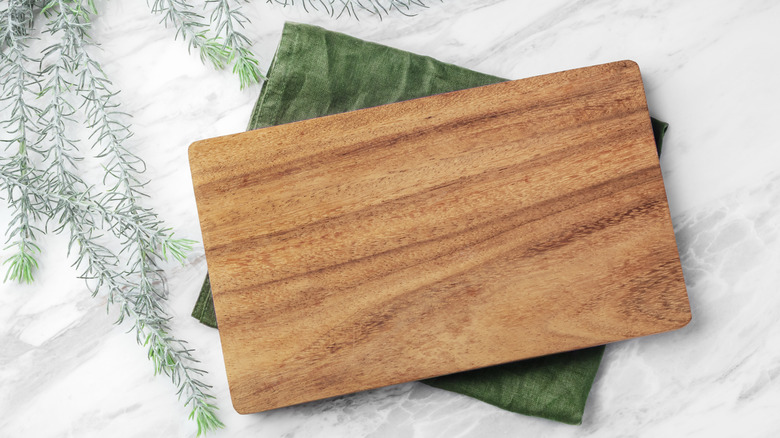 Thớt gỗ trên khăn xanh có cây xanh