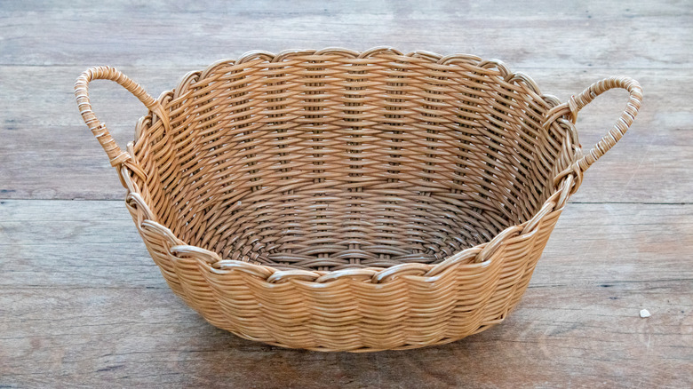 Giỏ đan có tay cầm đặt trên mặt gỗ