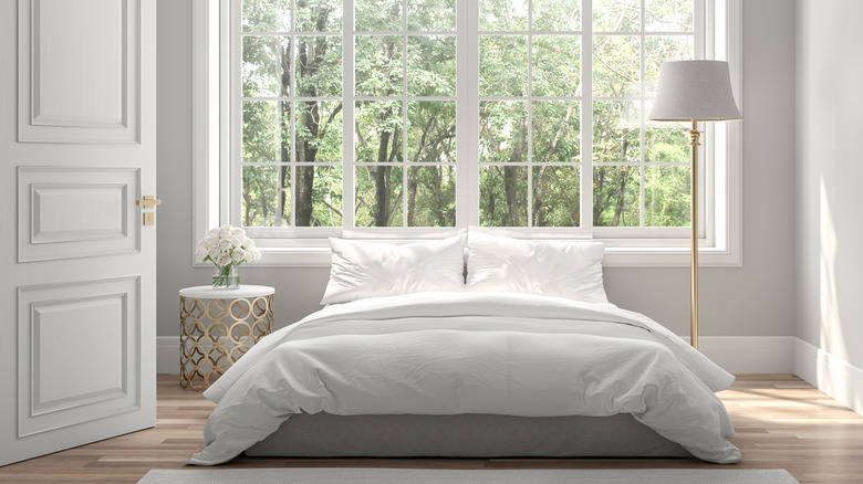 Phòng ngủ màu xám trắng hiện đại với khoảng trống trên bức tường cạnh giường ngủ