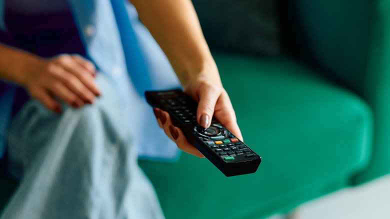 Người phụ nữ sử dụng điều khiển TV