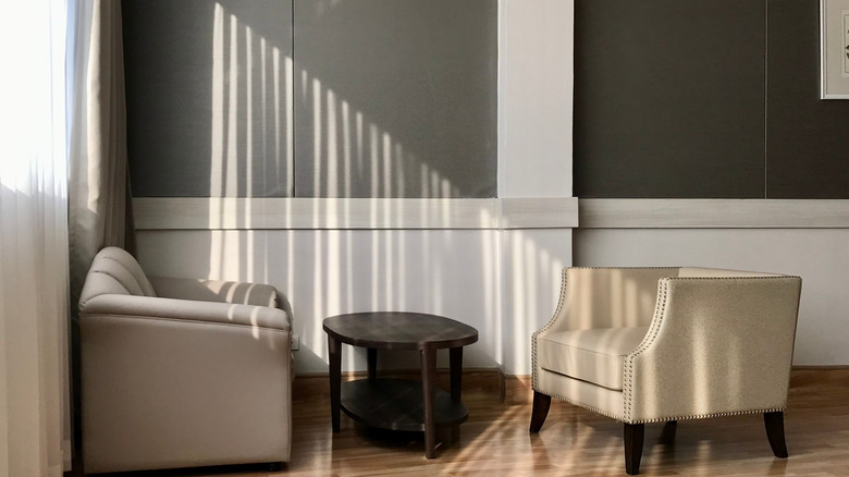 Phòng khách với những bức tường nửa xám nửa trắng với những đường gờ trang trí