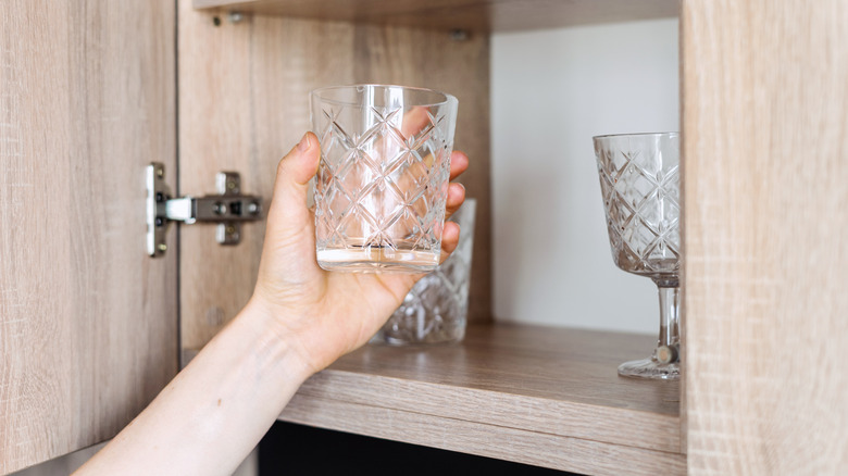 Người lấy ly uống nước ra khỏi tủ