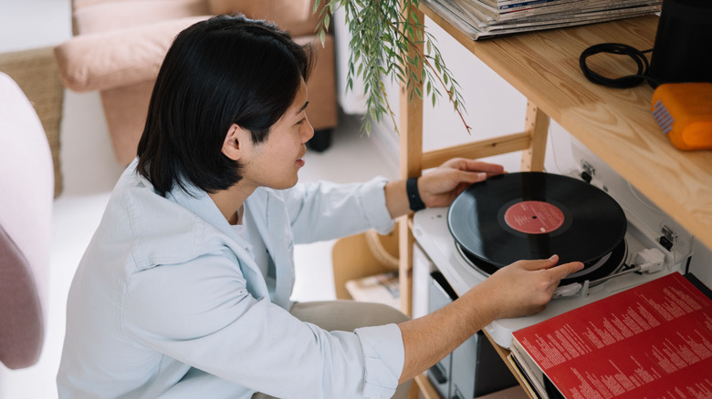 Người đàn ông đặt bản ghi vào máy ghi âm