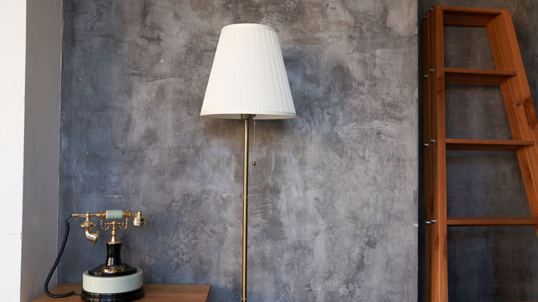 Đèn sàn cũ, điện thoại cổ và thang trong phòng