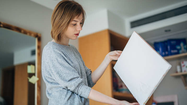 Một người phụ nữ nhìn vào một tấm vải trắng trơn