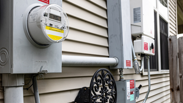 Đế và đồng hồ đo, bộ biến tần năng lượng mặt trời và ngắt kết nối được gắn vào tường bên ngoài của ngôi nhà