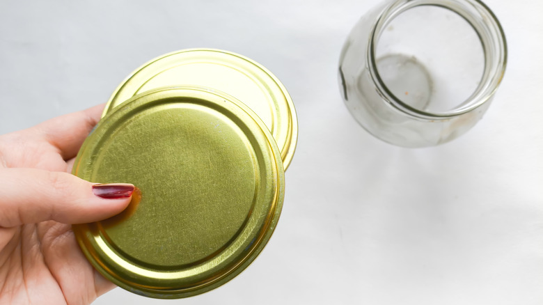 Người phụ nữ cầm nắp lọ