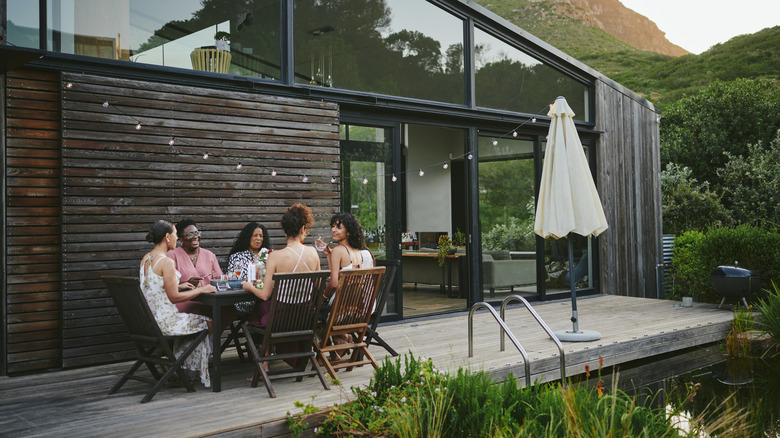 Nhóm phụ nữ đang thưởng thức bữa ăn tại bàn ăn ngoài trời trên hiên