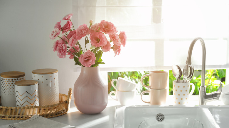 Rèm roman trên cửa sổ phía sau bồn rửa nhà bếp