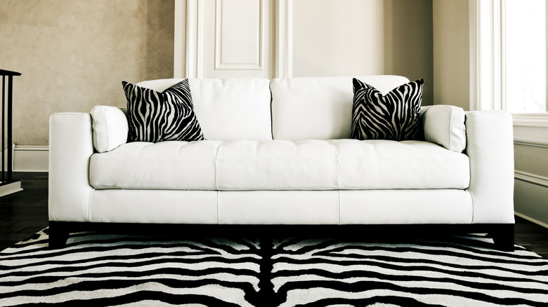 Tấm thảm in hình ngựa vằn dưới ghế sofa màu trắng