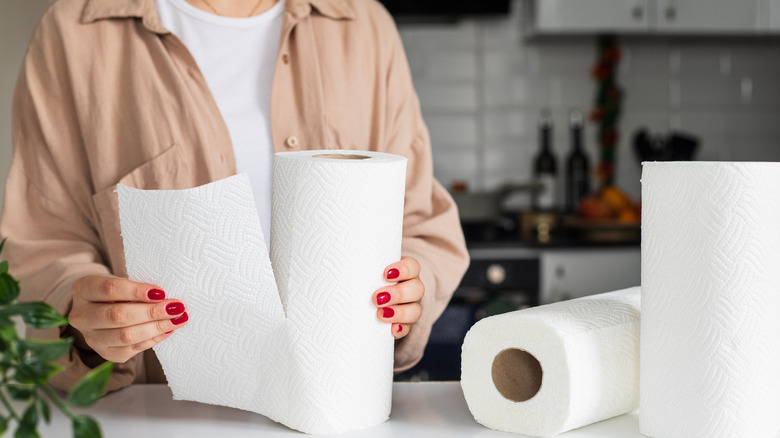 Người phụ nữ xé tờ khăn giấy trong bếp