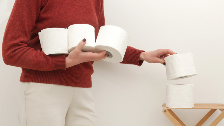 Người mang vài cuộn giấy vệ sinh vào phòng tắm