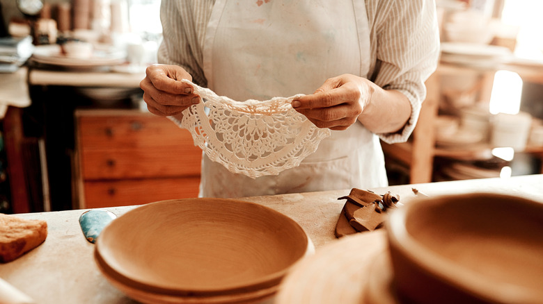 Người cầm khăn lau tay gần quầy có khay trên đó