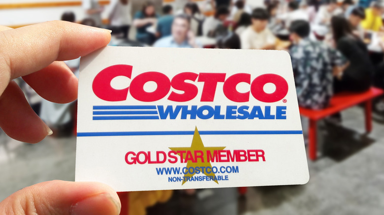một người cầm thẻ Costco bên trong cửa hàng