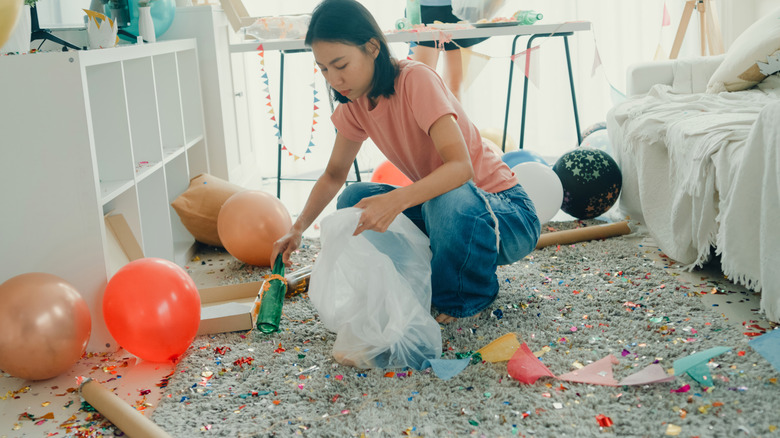 Một người phụ nữ đang lau sàn sau bữa tiệc