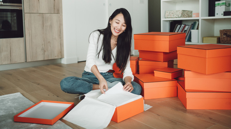 Một người phụ nữ mở hộp giày màu cam