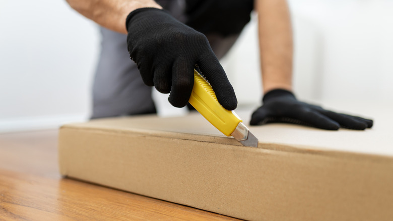 một người cắt bìa cứng bằng máy cắt hộp