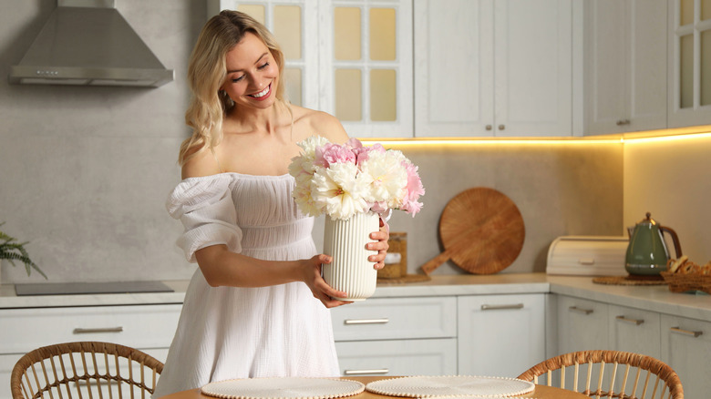 một người phụ nữ cầm bình hoa
