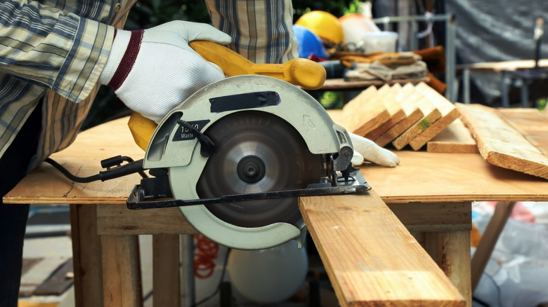 Người cắt ván gỗ bằng cưa tròn