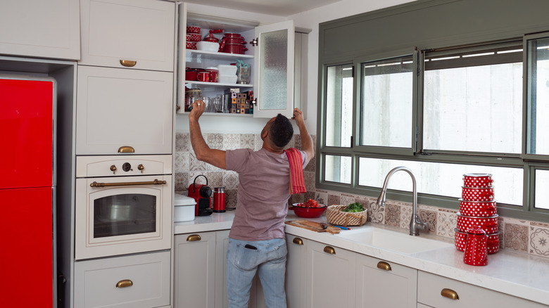 người đứng trong bếp mở tủ