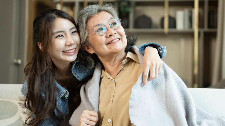 Một phụ nữ trẻ ôm bà ngoại lớn tuổi của mình khi cả hai đều mỉm cười