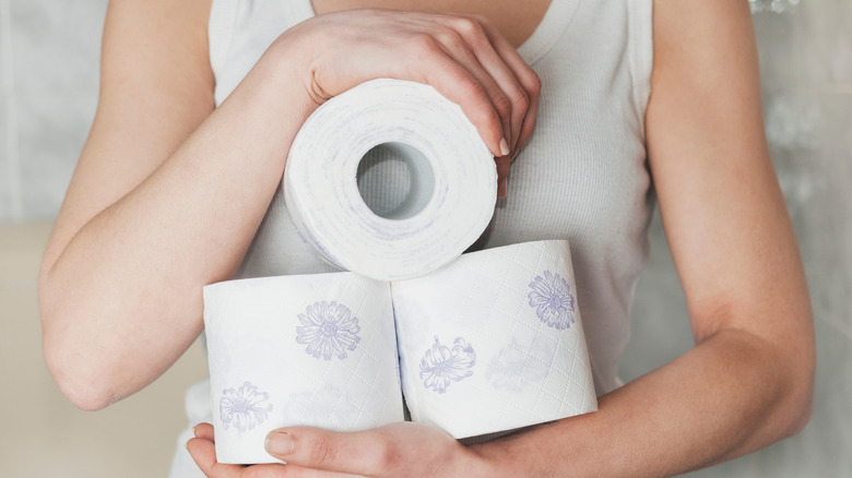 Một người cầm cuộn giấy vệ sinh