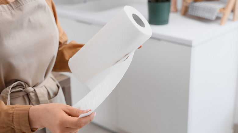 Một người kéo khăn giấy ra khỏi cuộn