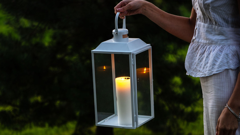 Người phụ nữ cầm đèn lồng thắp nến bên trong