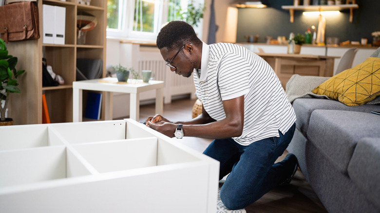Người đàn ông đang lắp ráp tủ sách IKEA