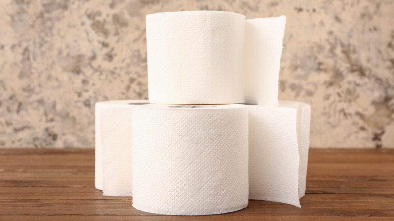 Một xấp giấy vệ sinh nhỏ trên bàn gỗ